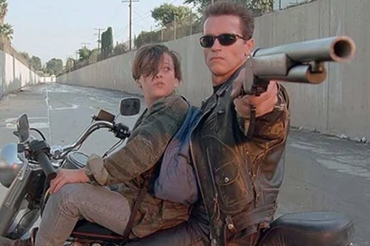 two people on motorbike, one holding gun